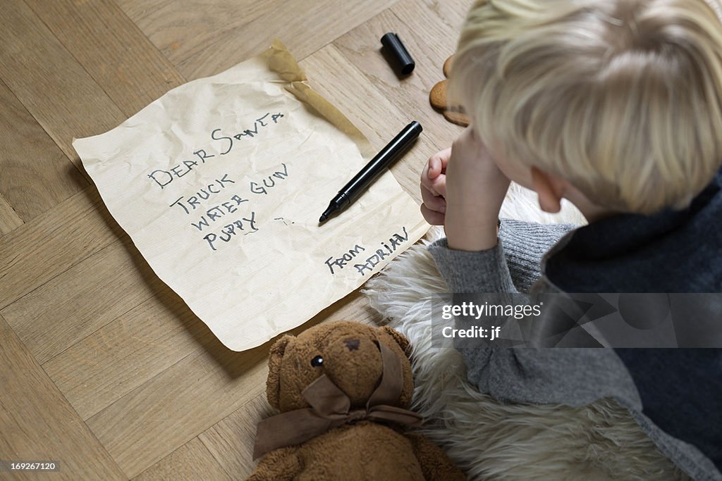 Boy writing Christmas list for Santa