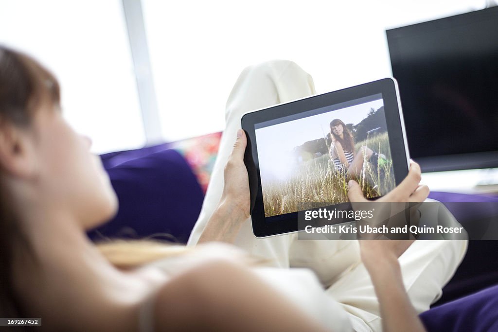Woman using tablet computer on sofa