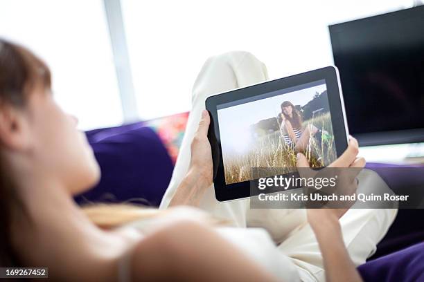 woman using tablet computer on sofa - film 2012 fotografías e imágenes de stock