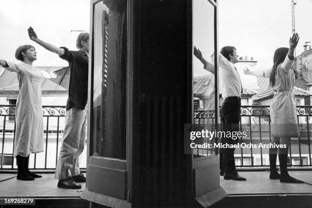 Juliet Berto, Michel Semeniako, Jean-Pierre Leaud, and Anne Wiazemsky stretching out on patio in scene from the film 'La Chinoise', 1967.