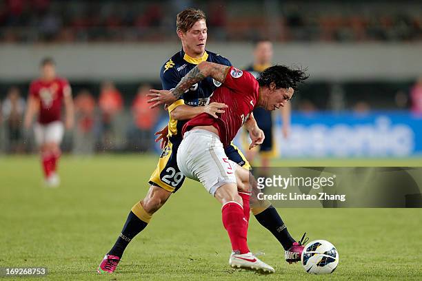 Nick Fitzgerald of Central Coast Mariners challenges Zhang Lipeng of Guangzhou Evergrande during the AFC Champions League knockout round match...