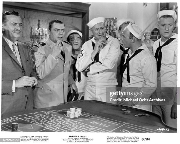 Ernest Borgnine, Carl Ballantine, and Gavin MacLeod gathered around craps table in a scene from the film 'McHale's Navy', 1964.