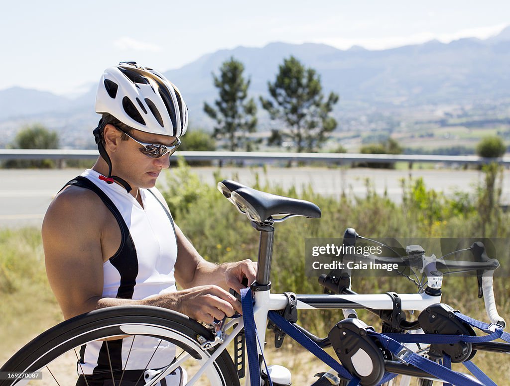 Man adjusting bicycle outdoors