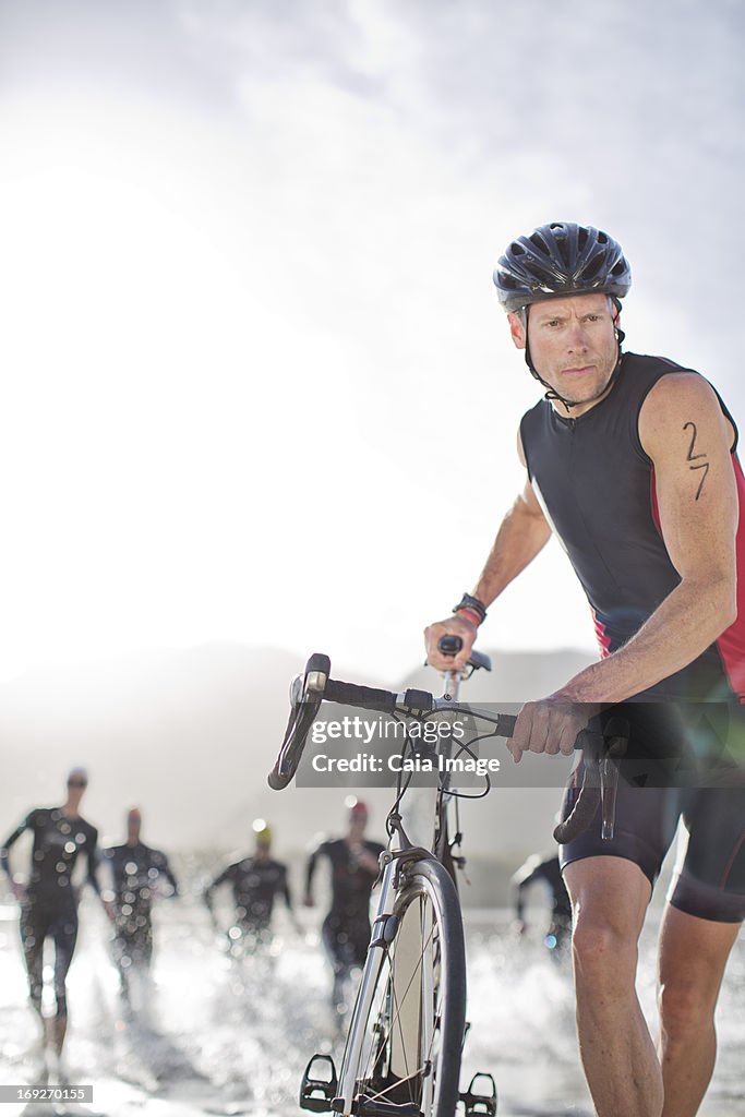 Man pushing bicycle on beach