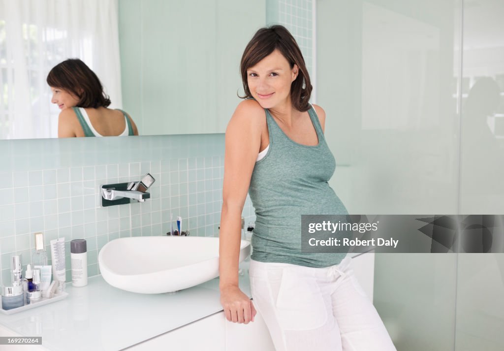 Mulher grávida Inclinar-se no lavatório