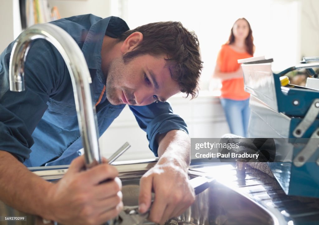 Plumber working on kitchen sink