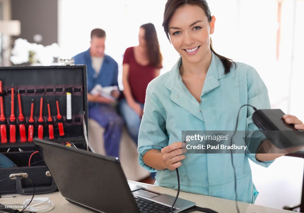 Female electrician using laptop in home