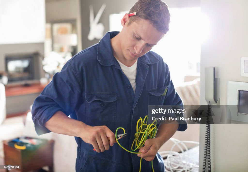 Electrician cutting wires in home