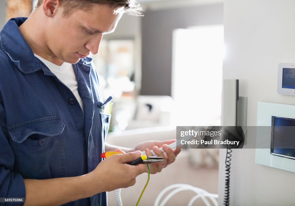 Eletricista trabalhando no telefone de casa