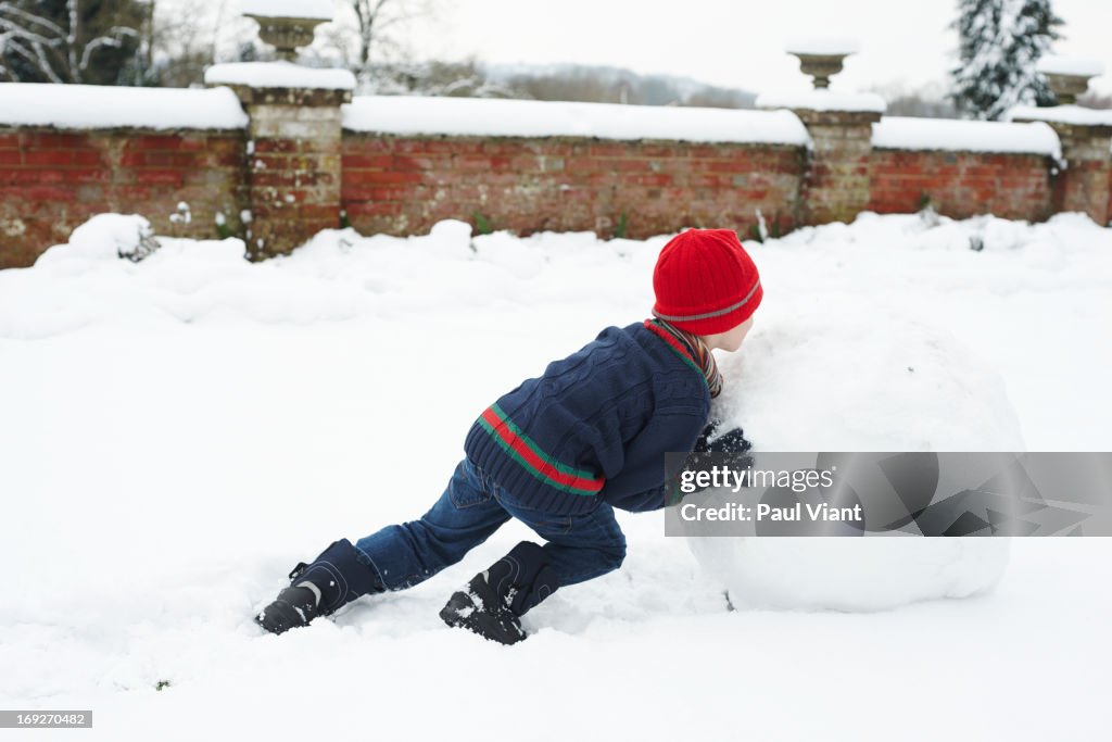 Boy making snowman outdoors