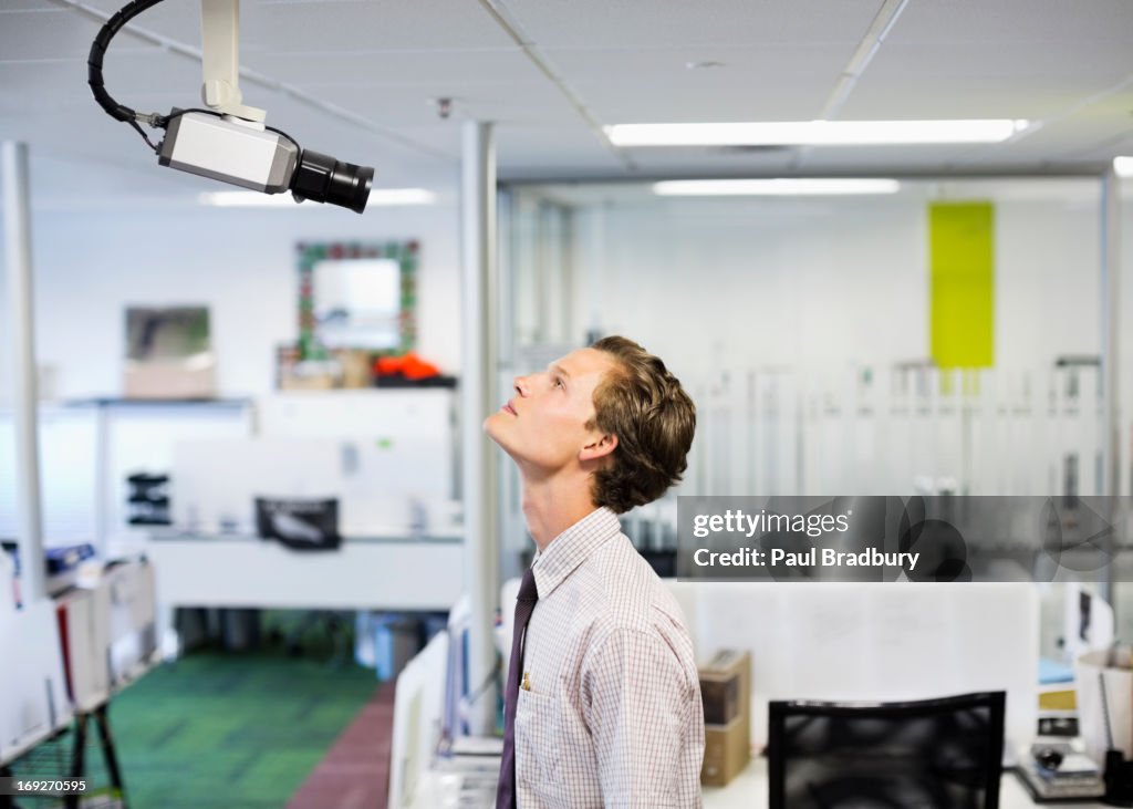 Businessman examining security camera in office