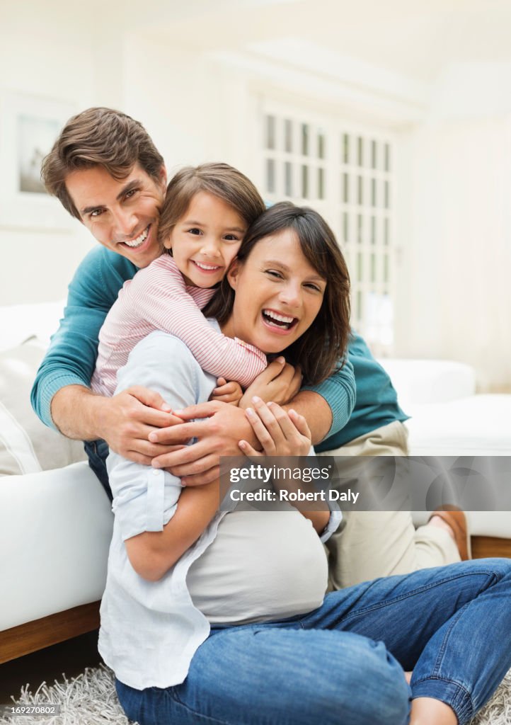 Family hugging in living room