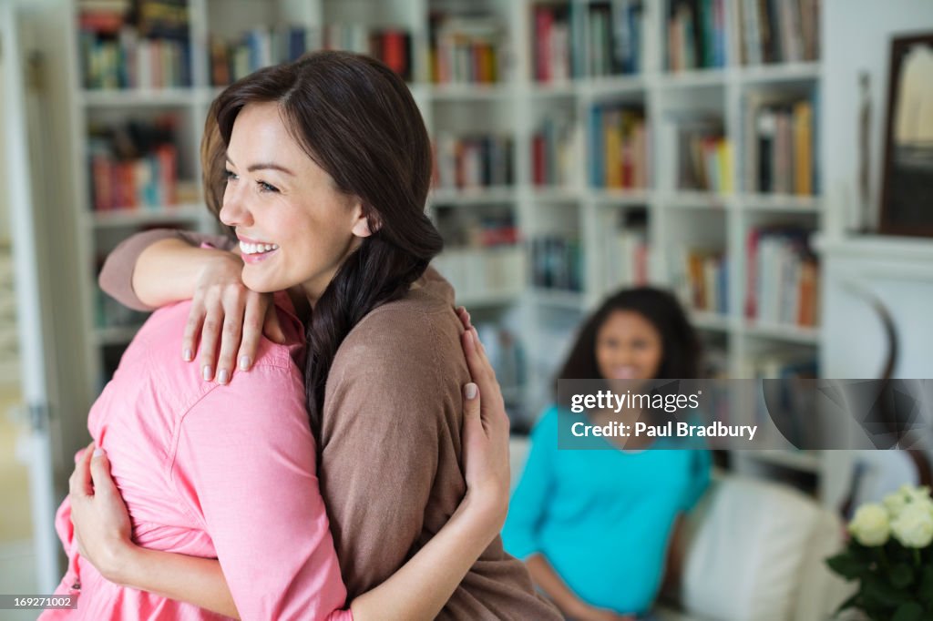 Women hugging in living room