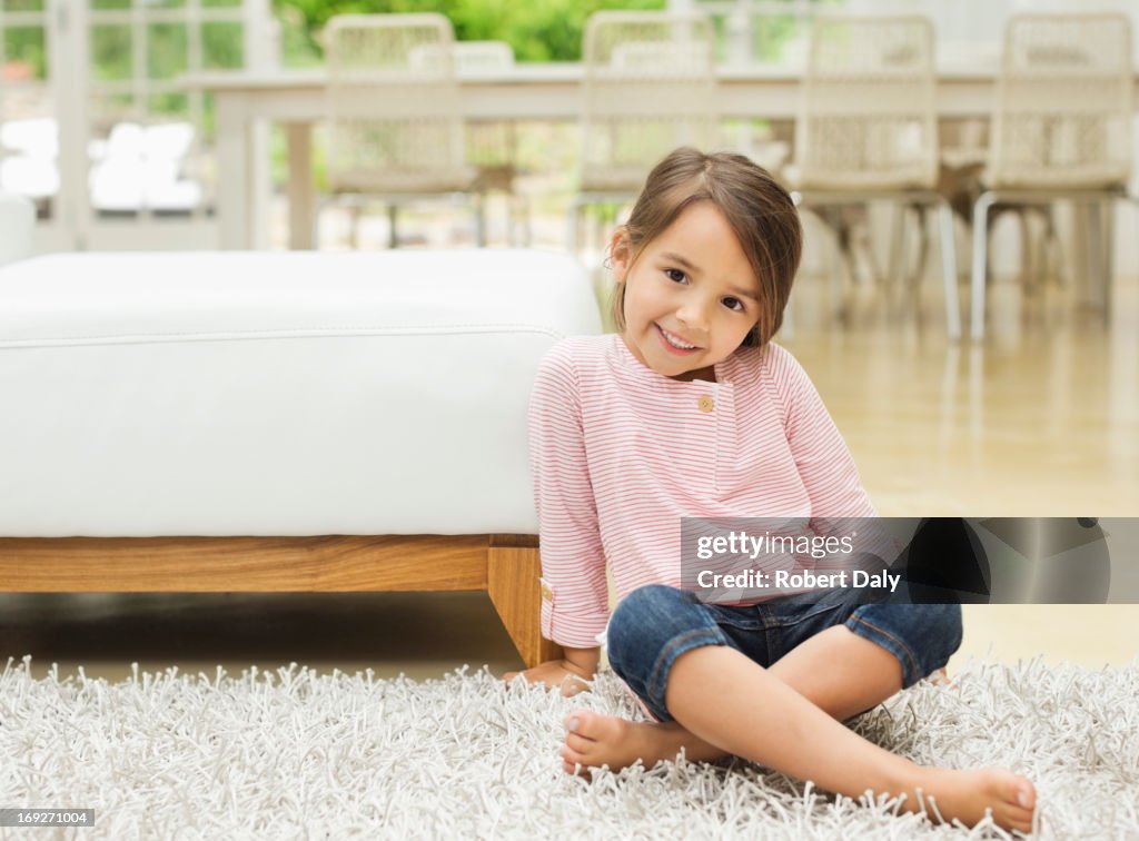 Smiling girl sitting on rug