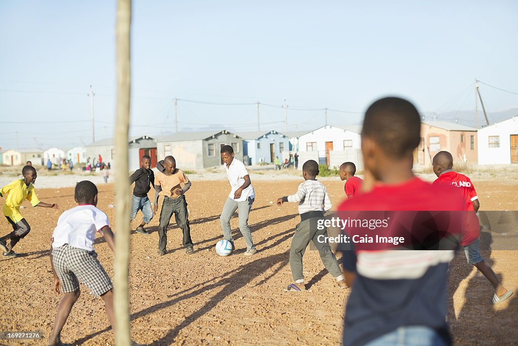 Garçons jouant au football ensemble dans la terre field