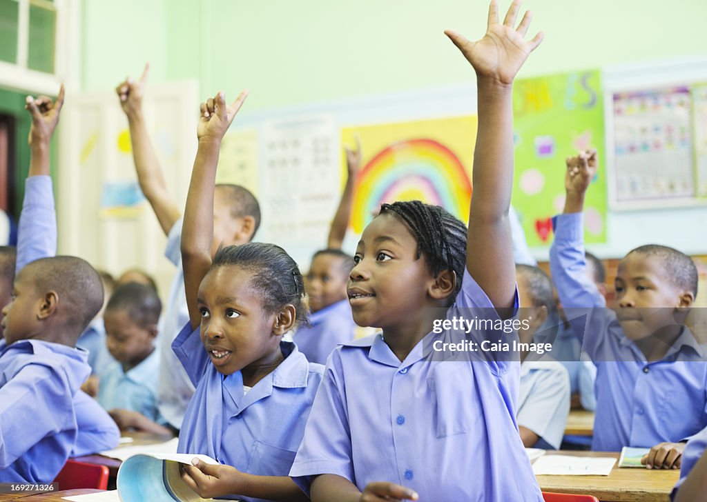 Students raising hands in class