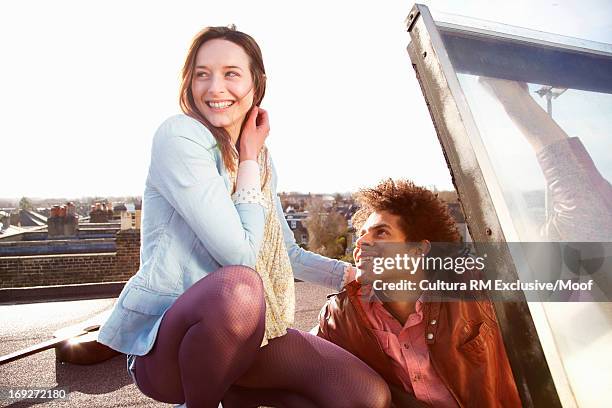 young couple opening hatch onto roof terrace - hatch stock-fotos und bilder