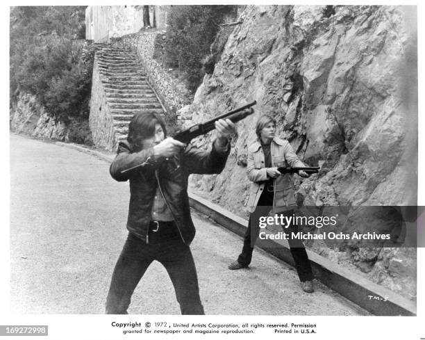 Charles Bronson and Jan-Michael Vincent aiming guns in a scene from the film 'The Mechanic', 1972.