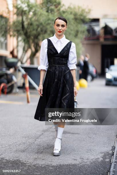 Mary Leest is seen wearing hoop silver earrings, silver pumps, white long socks, a silver mini Chanel handbag with gold hardware, a white shirt and a...