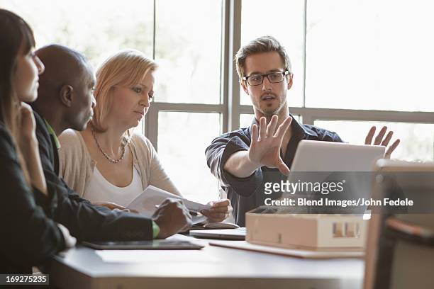 business people using laptop in meeting - persuasion stock pictures, royalty-free photos & images