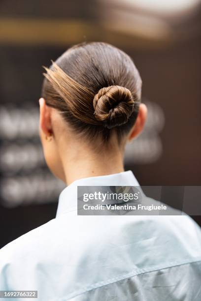 Guest is seen wearing her hair in a bun with a white shirt outside the Fendi show during Milan Fashion Week Womenswear Spring/Summer 2024 on...