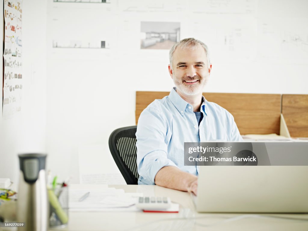 Mature businessman at laptop in startup office