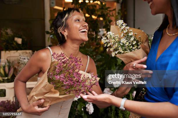 happy young women with flower bouquets - buying flowers stock pictures, royalty-free photos & images