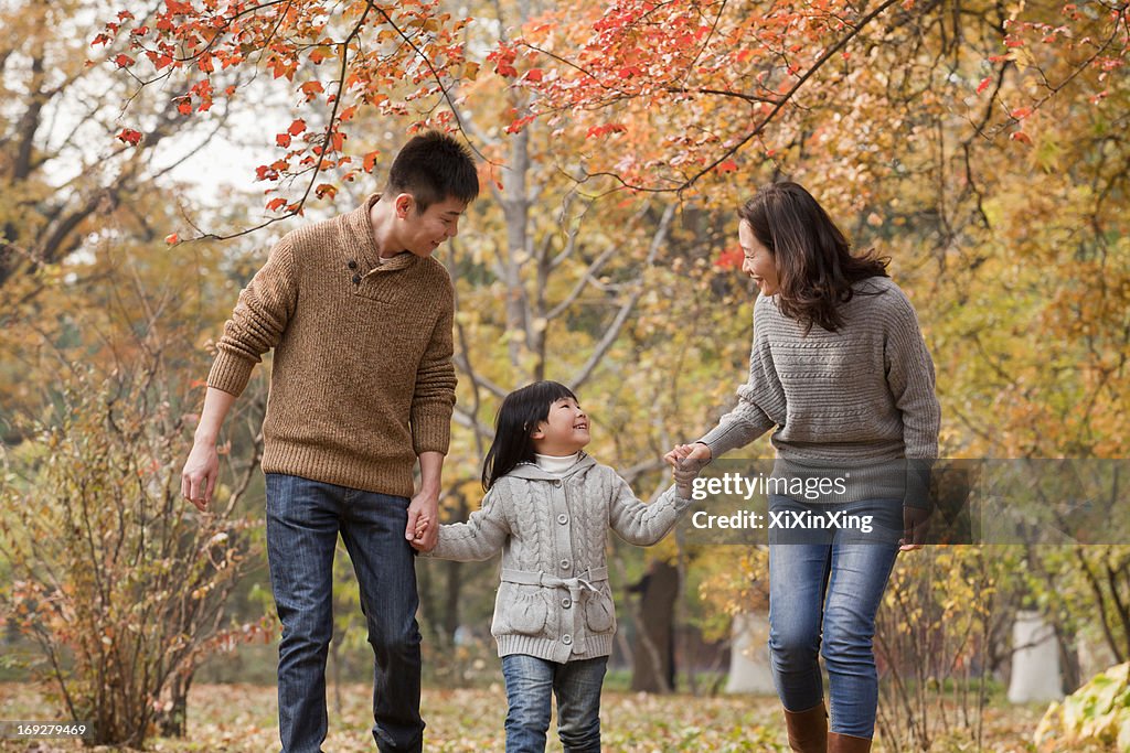 Family walking through the park in the autumn