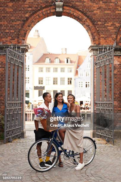 young man and women with bicycle on street - oresund region 個照片及圖片檔