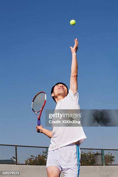 adult men serving the tennis ball - sacada fotografías e imágenes de stock