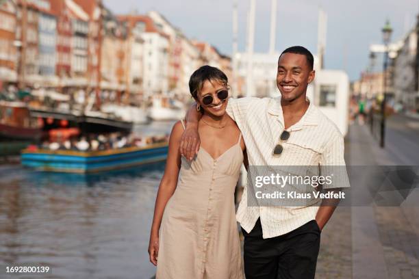 happy young man and woman walking on pier - escapism stock pictures, royalty-free photos & images
