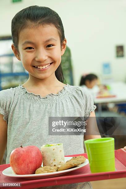 school girl holding food tray in school cafeteria - young choice beijing activity stock pictures, royalty-free photos & images