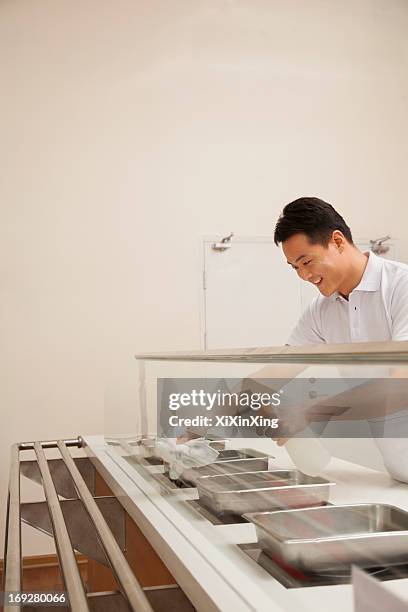 Cafeteria Worker Cleaning Food Serving Area, Foto de stock
