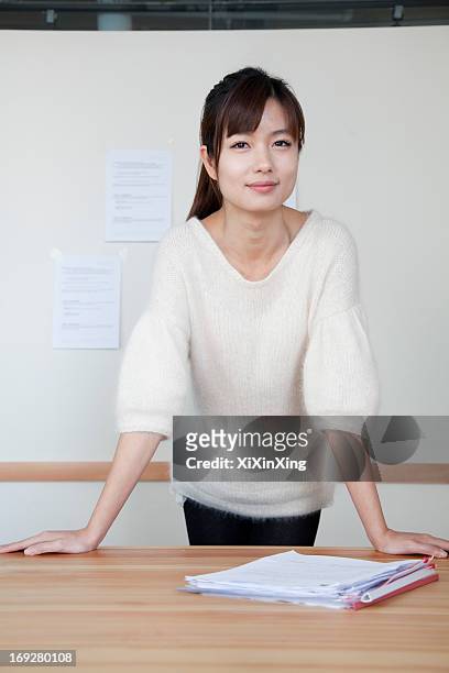 young businesswoman standing with her hands on the table, portrait - woman table standing stock pictures, royalty-free photos & images
