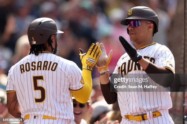 Eguy Rosario congratulates Juan Soto after he scored on an RBI single by Luis Campusano of the San Diego Padres during the seventh inning of a game...