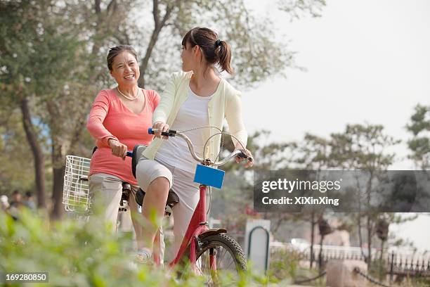 grandmother and granddaughter riding tandem bicycle, beijing - asian granny pics stock pictures, royalty-free photos & images