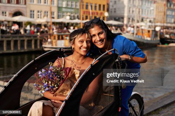 happy multiracial friends enjoying ride in cargo bike - oresund region 個照片及圖片檔
