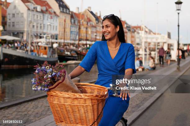 happy young woman riding bicycle in city - oresund region 個照片及圖片檔