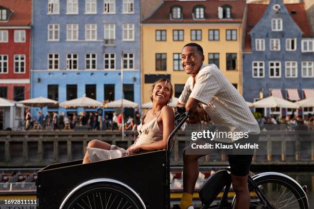 happy young man with girlfriend in cargo bike - copenhagen summer bildbanksfoton och bilder