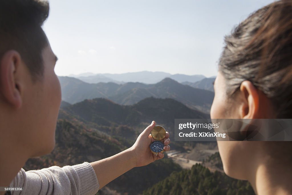 Young couple hiking and looking at the compass