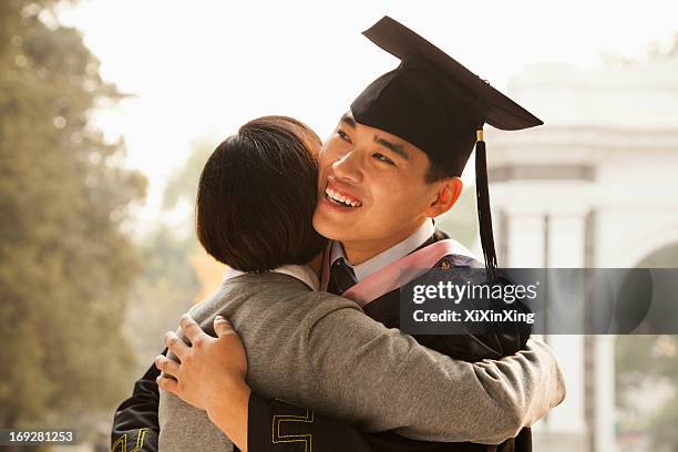 mother and graduate hug - parent student stock pictures, royalty-free photos & images