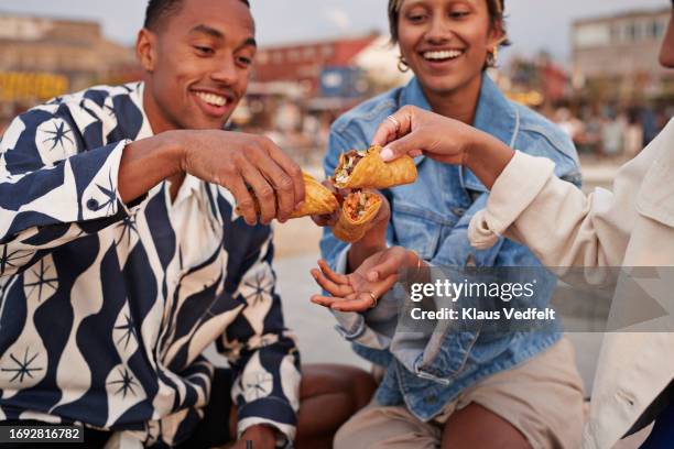 multiracial friends toasting tacos on promenade - taco stock pictures, royalty-free photos & images