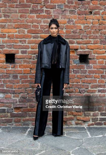 Pritika Swarup wears black shearling leather jacket, two tone striped pants, bag outside Alberta Ferretti during the Milan Fashion Week - Womenswear...