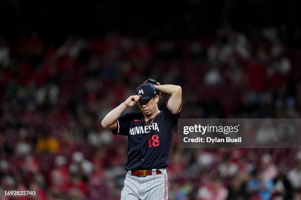 Kenta Maeda of the Minnesota Twins adjusts his cap while on the mound in the fifth inning against the Cincinnati Reds at Great American Ball Park on...