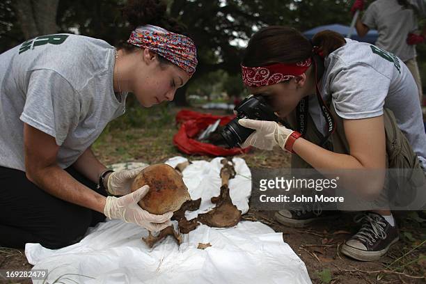 Anthropology students photograph the skeleton of a suspected undocumented immigrant after the bones were exhumed from a gravesite on May 22, 2013 in...