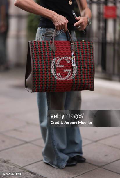 Guest is seen outside Molly Goddard show wearing blue distressed oversized Acne Studios jeans, red checkered logo Gucci tote bag and black ballet...