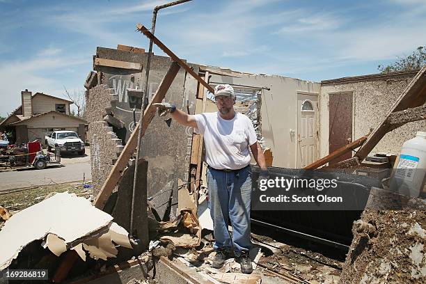 Mike Newbury cleans debris from his late father-in-law's home after it was destroyed when a tornado ripped through the area on May 22, 2013 in Moore,...