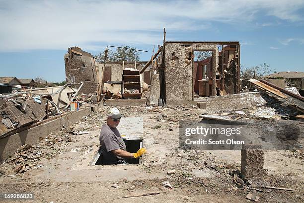 Dean Dye looks over a storm shelter in a home that was destroyed by a tornado on May 22, 2013 in Moore, Oklahoma. The shelter is across the street...