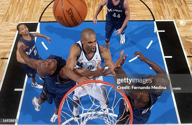 Grant Hill of the Orlando Magic battles for the rebound against Jerry Stackhouse and Brendan Haywood of the Washington Wizards during the NBA game at...
