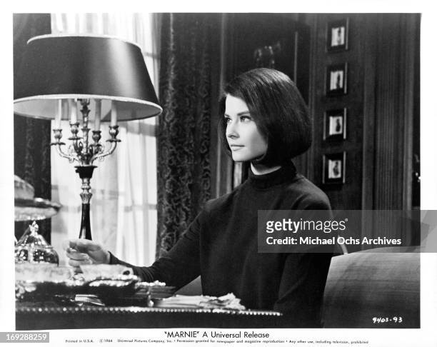 Diane Baker searching through private papers in a scene from the film 'Marnie', 1964.